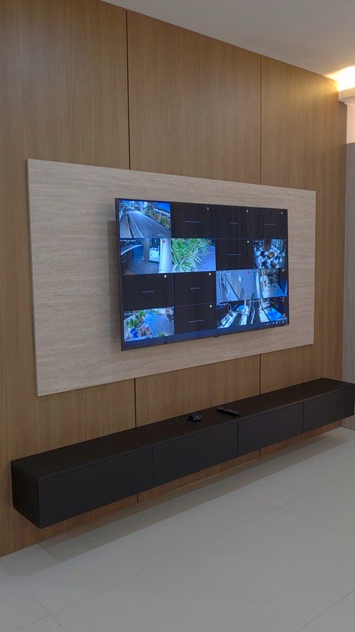 Completed security-room media wall with timber panelling and floating black storage